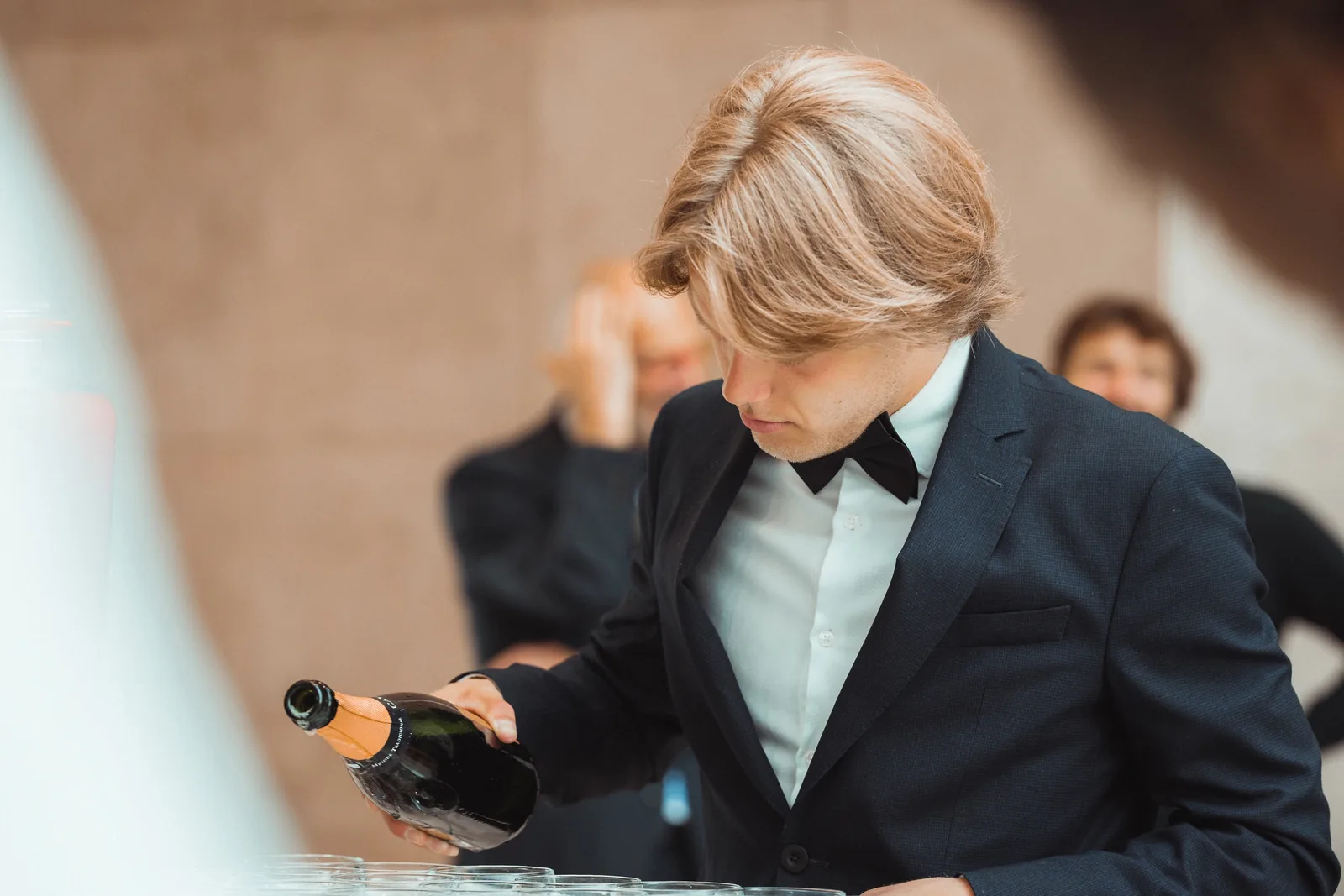 Close-up van een maître in maatpak die champagne inschenkt